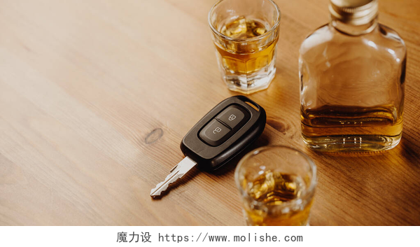 木制桌子上的钥匙和酒水关门的车钥匙和非常浓烈的酒精在桌上，不要酒后驾车的概念